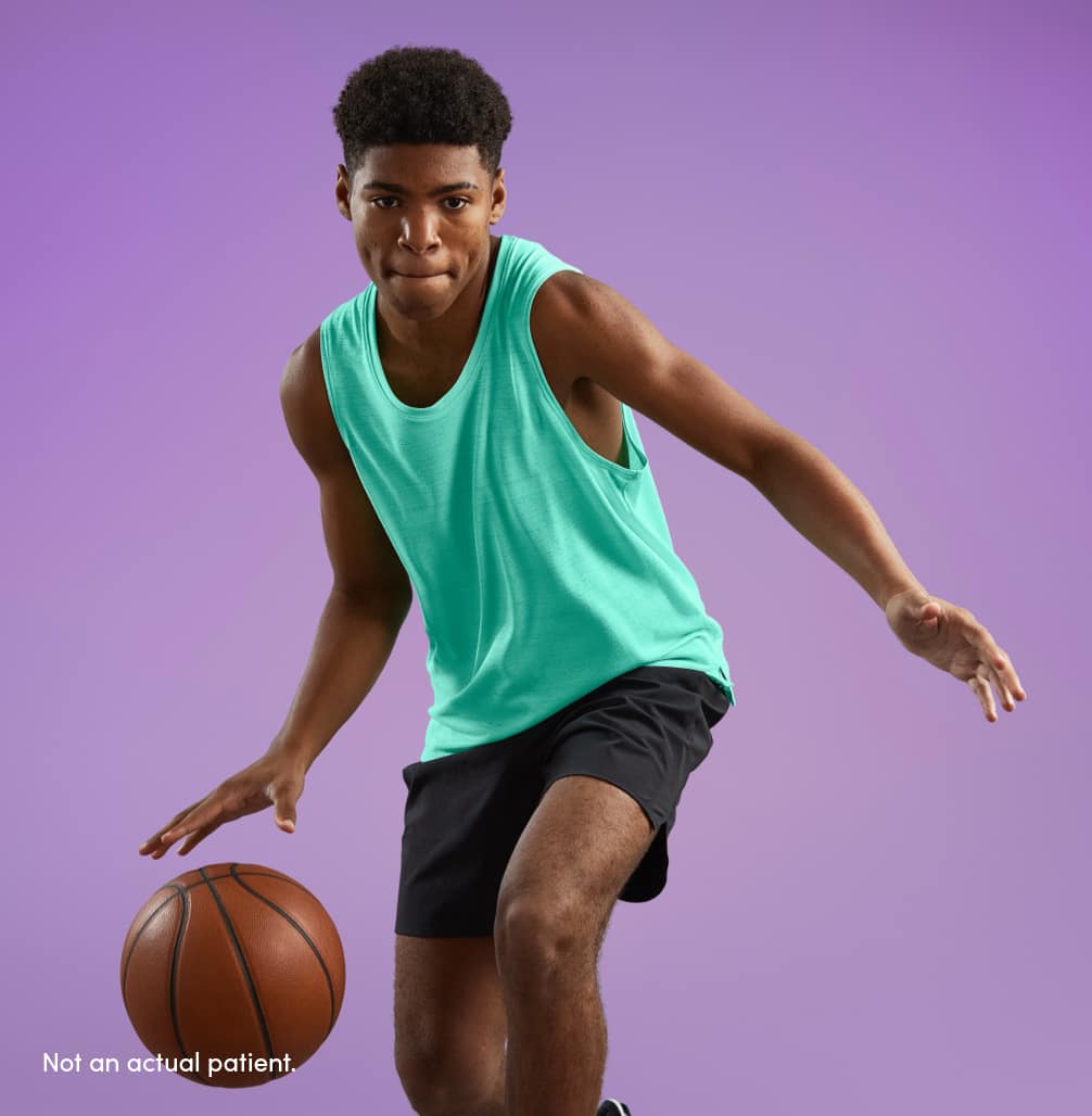 Teen boy with clearer skin dribbling basketball in loose fitting clothes represents acne skincare tip 1: stay fresh