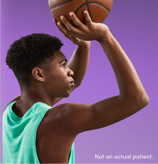 Teen boy ready to shoot basketball reflects confidence gained from using an acne treatment recommended by dermatologists