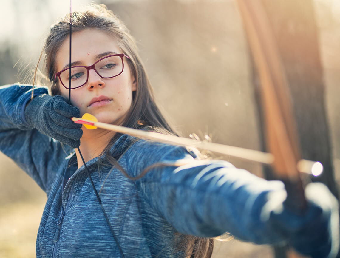 Teen girl with bow & arrow represents trifarotene, the secret weapon in AKLIEF® Cream that targets the root cause of acne