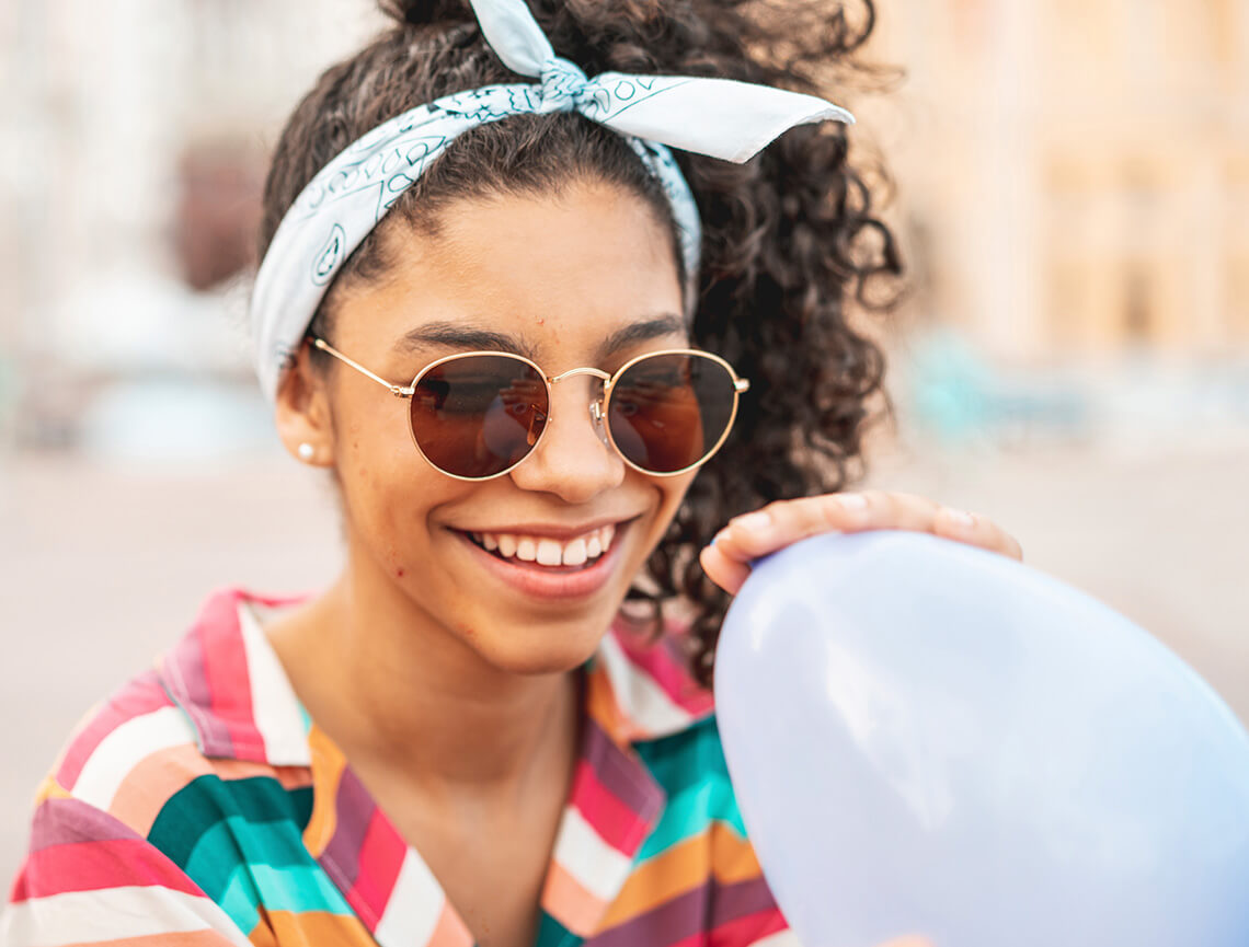 Smiling teen girl wearing sunglasses represents acne relief after following talking points in the doctor discussion guide