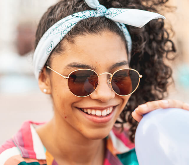 Smiling teen girl wearing sunglasses represents acne relief after following talking points in the doctor discussion guide